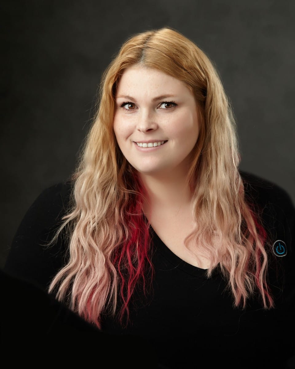 a woman with long blonde hair smiling for the camera