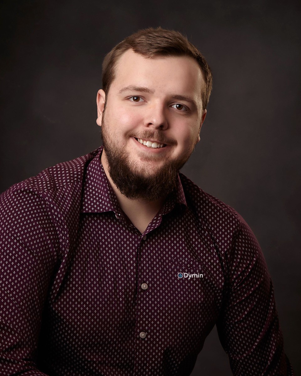 a man with a beard smiling at the camera