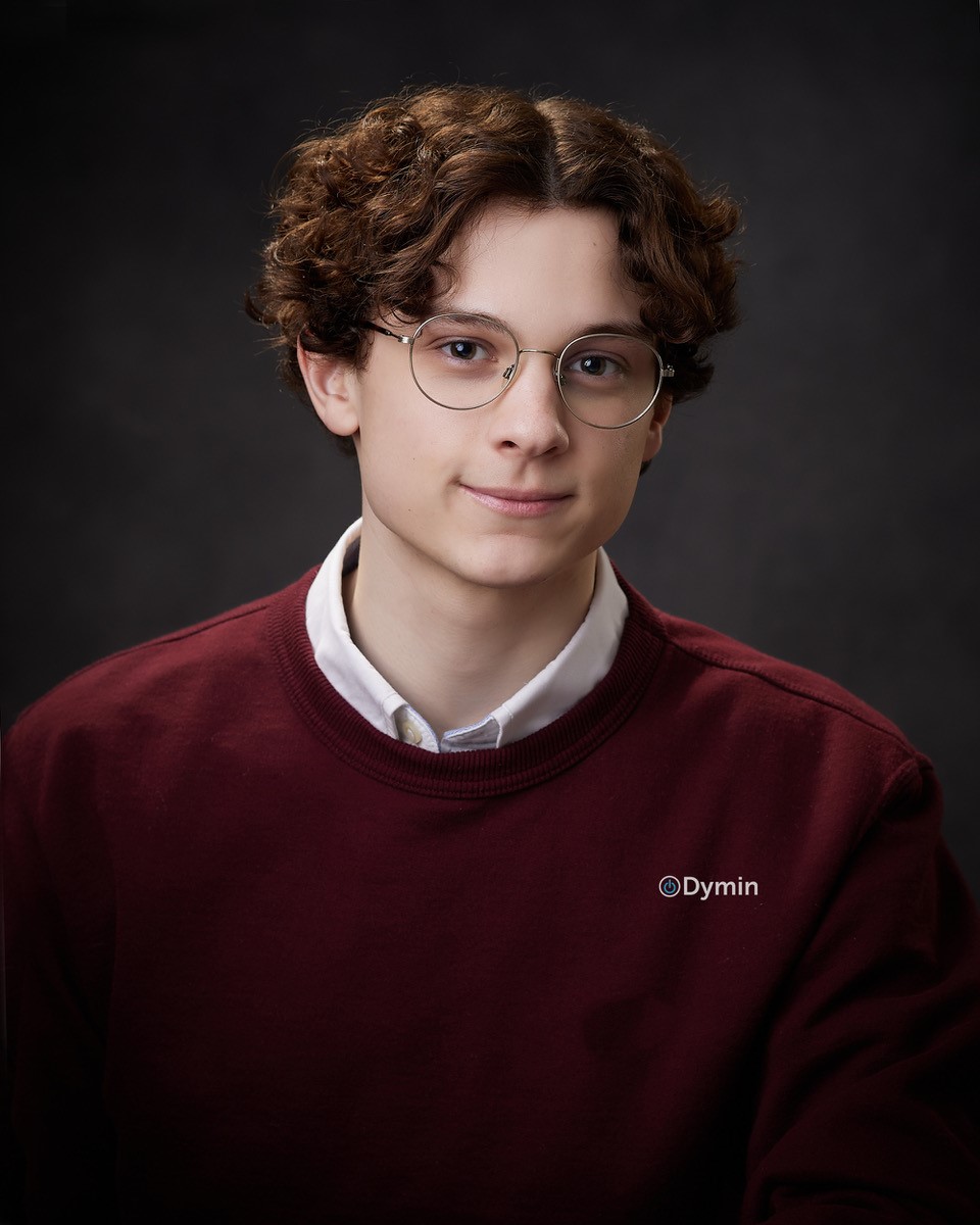 a young man wearing glasses and a maroon sweater