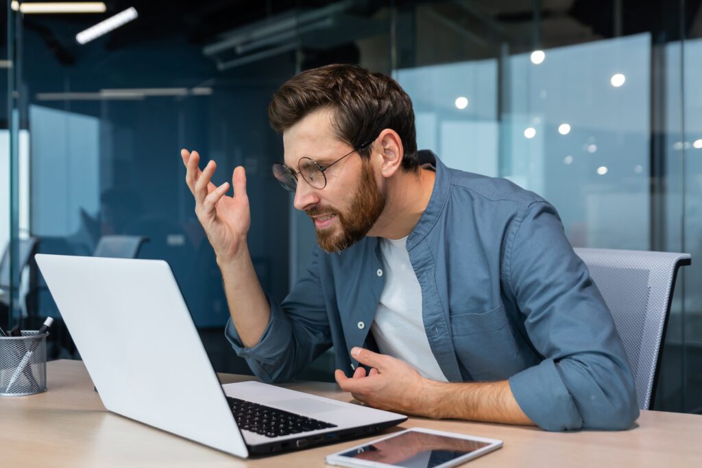 a man sitting at a table with a laptop in front of him