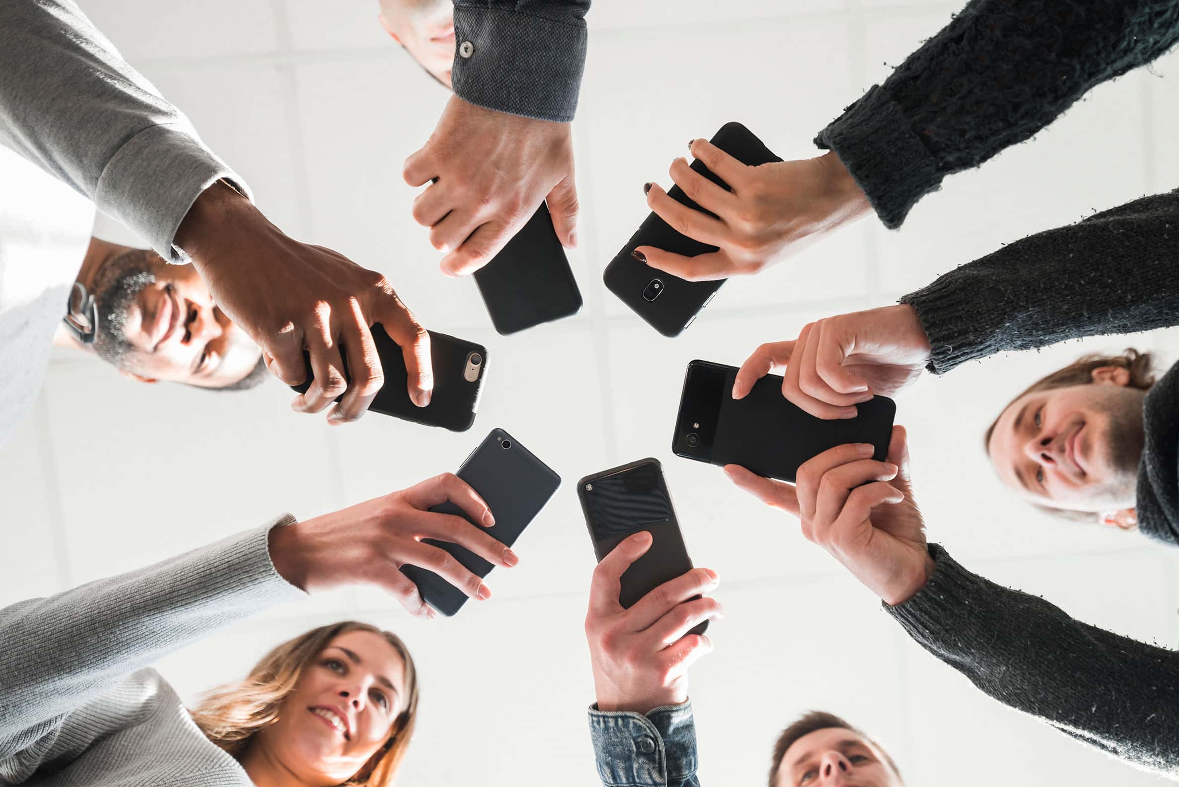a group of people standing in a circle holding cell phones