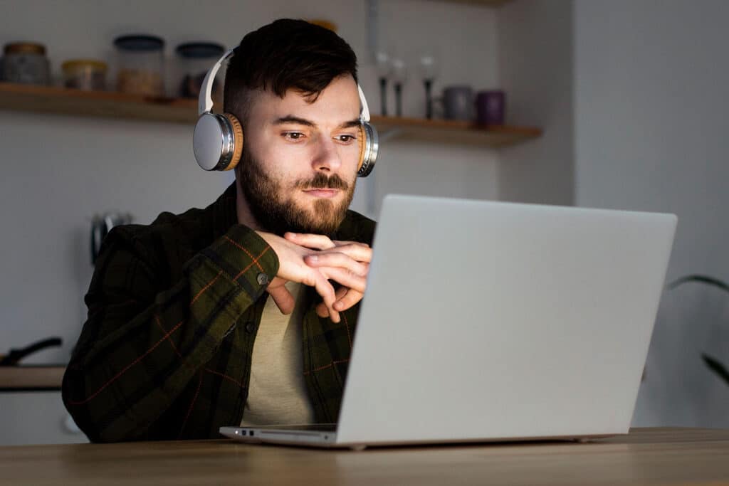 a man with headphones on looking at a laptop