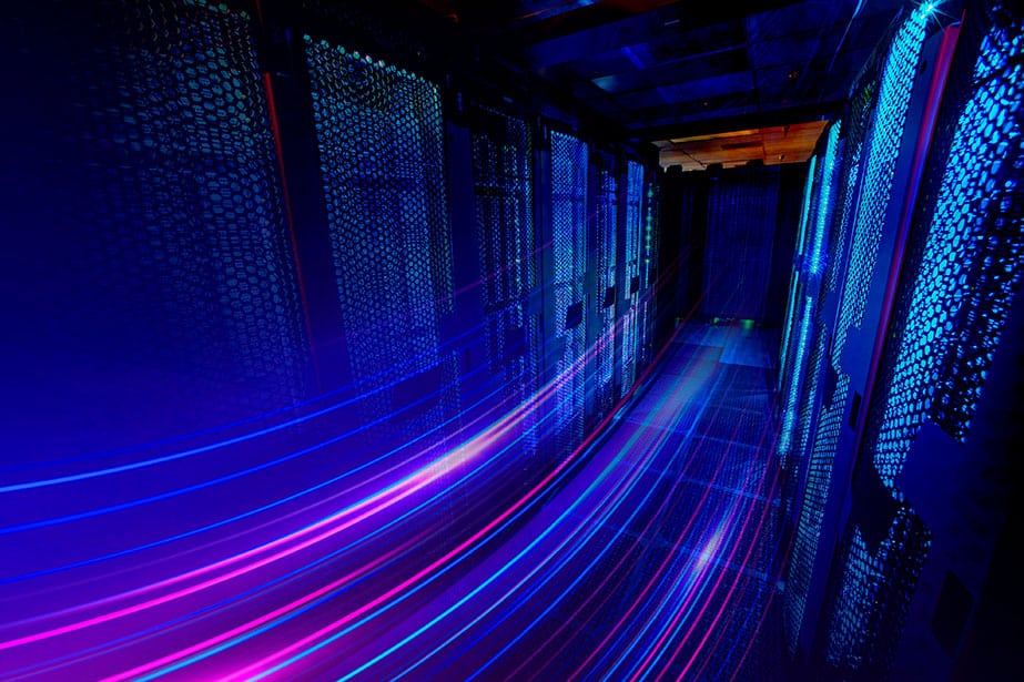 a long exposure photo of a hallway with blue and purple lights