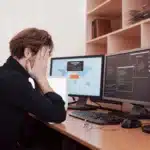 a person sitting at a desk with a computer